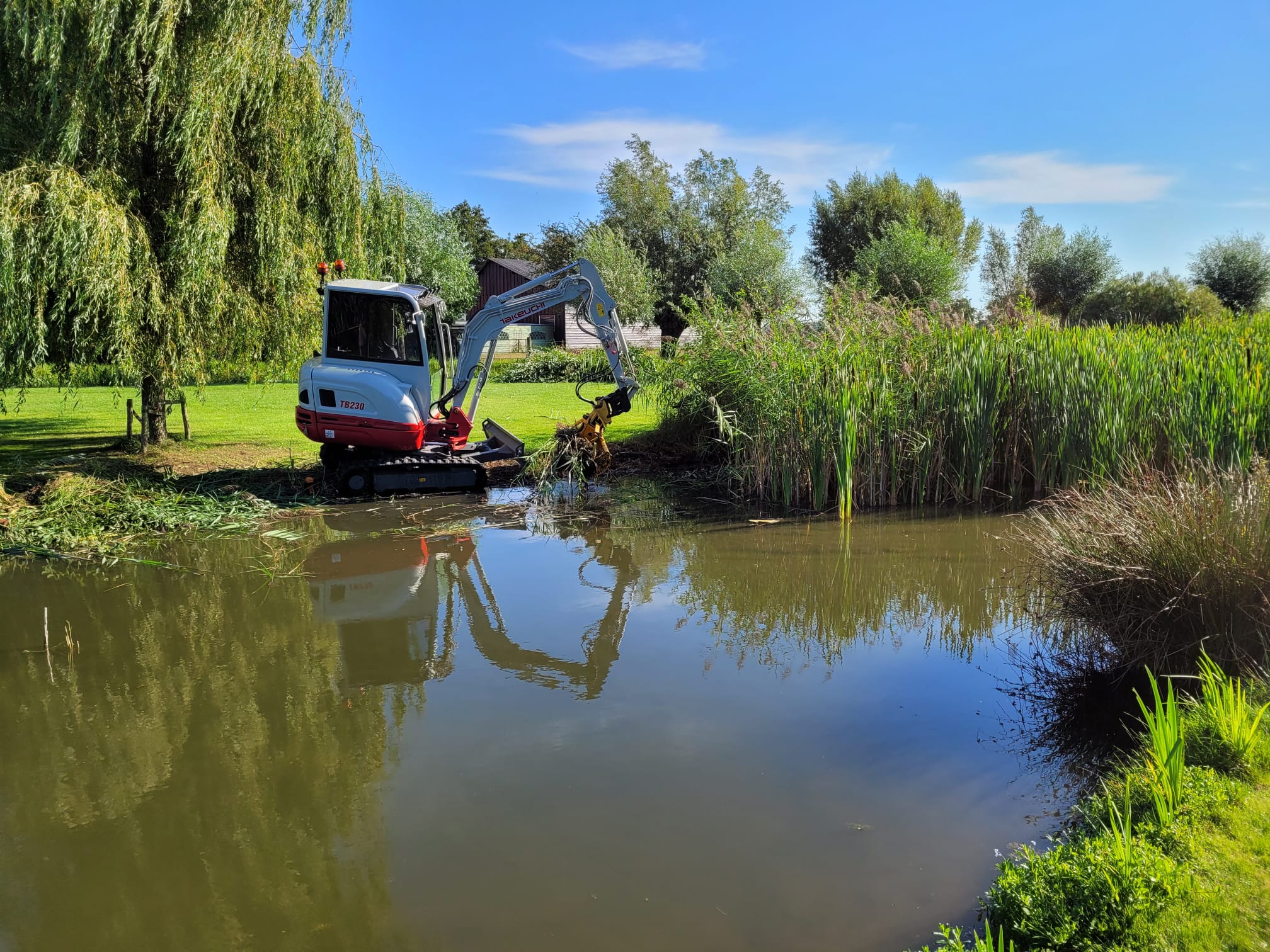 Van Der Pluym op locatie — minigraver bij de waterkant